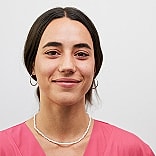 Smiling woman in pink top and necklace