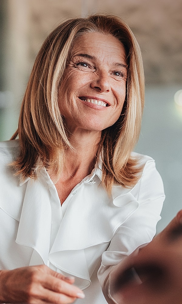 Smiling woman in a bright indoor setting.