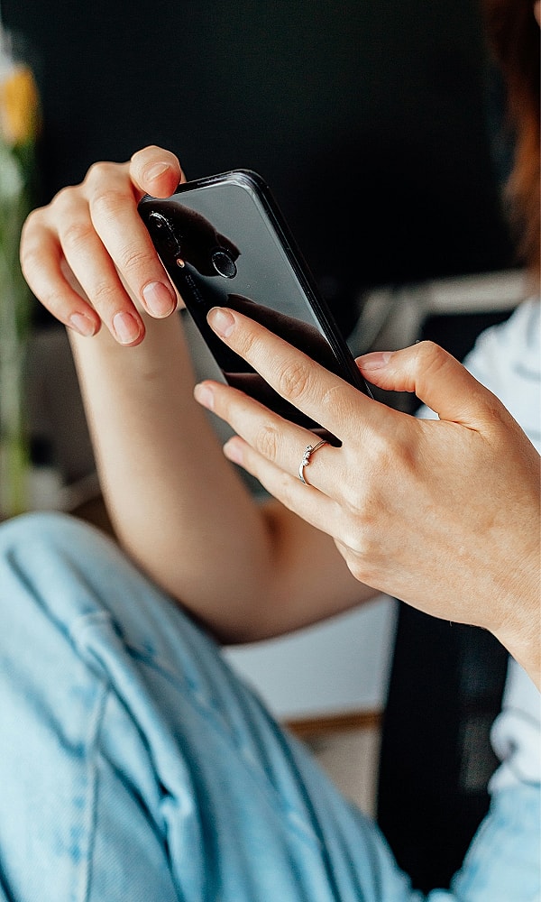 Person holding a smartphone, casually dressed.