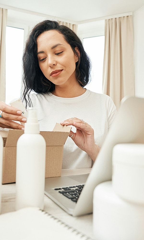 Woman unpacking a box at a desk.