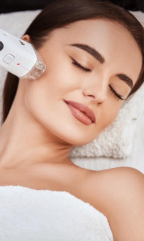 Facial treatment with device on relaxed woman.