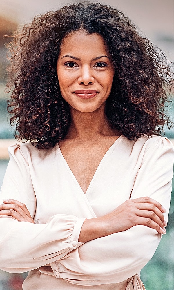 Confident woman smiling with arms crossed.
