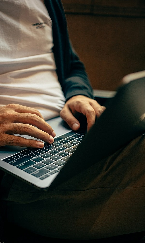Person typing on a laptop in casual setting.