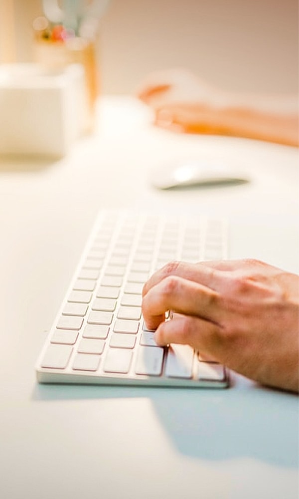 Person typing on a keyboard at a desk.