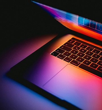 Colorful laptop with glowing keyboard and screen.