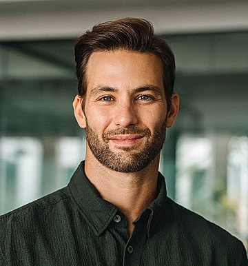 Smiling man in a green shirt, indoor setting.