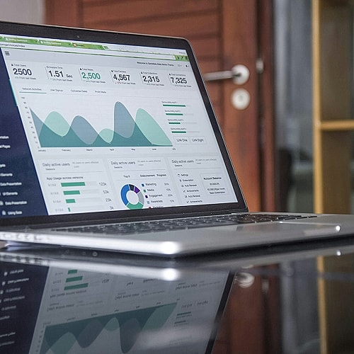 Laptop displaying analytics dashboard and graphs.