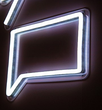 Neon speech bubble sign on wall