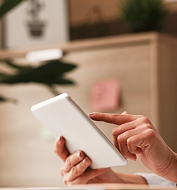 Person using a tablet in a cozy setting.
