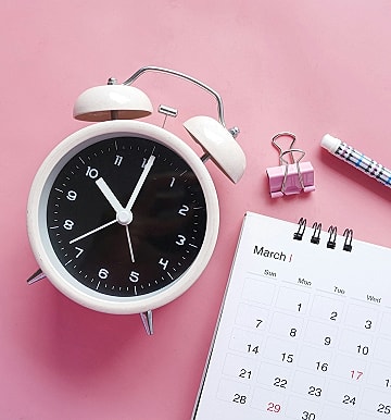 Clock and calendar on pink background.