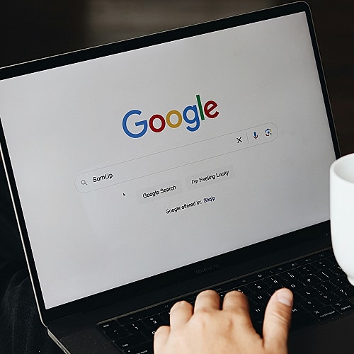 Person using Google search on a laptop.